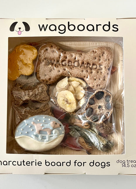 Wagboards charcuterie board for dogs with various treats in a clear window box.