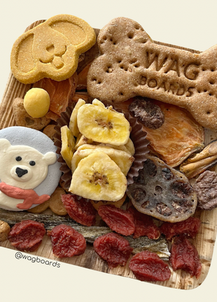 Dog treat board with various dog treats on a beige background